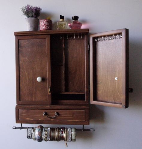 "This is a jewelry organizer / cabinet designed and crafted by me. Functional with an artistic flare is my goal when making functional pieces. Something you can use every day and be well-pleased to display in your bedroom or elsewhere as a piece of art. Designed on DARK WALNUT STAIN color, is meant to hold most of your jewelry in a way you can reach them easily. The main body has stainless bars and hooks for earrings of any length, a ring box for more than 10 rings , and a shelf for sunglasses, Jewelry Wall Cabinet, Jewerly Organizer Ideas Bedroom, Vintage Room Ideas Bedroom, Unique Jewelry Displays, Jewelry Organizer Cabinet, Diy Jewelry Cabinet, Earrings Storage, Organizer Cabinet, Earrings Display