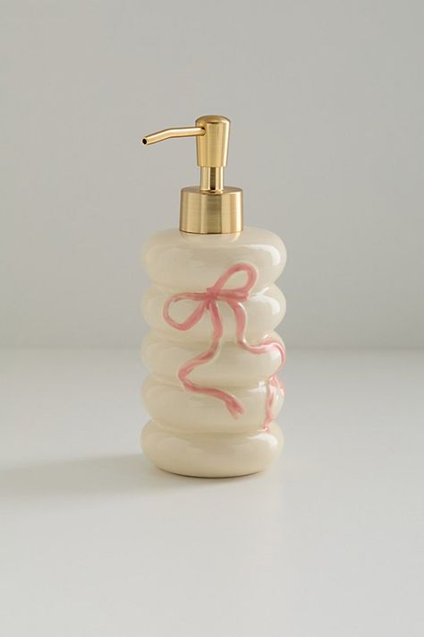 The bow on top of your cleanliness routine, this ceramic soap dispenser features a bubbled silhouette with a sweetly femme bow at the front. Pair it with other favorites from our Bow bathroom collection to create a coordinated set. Available exclusively at Urban Outfitters. Features Bow soap dispenser from UO Home Crafted from ceramic with a bow at the front One-of-a-kind hand-painted variance UO exclusive Content + Care Ceramic Wipe clean Imported Size Dimensions: 3.3" dia x 7.5" h Weight: 0.7 lbs | Bow Soap Dispenser in Rose at Urban Outfitters Room Wishlist, Girly Bathroom, Ceramic Soap Dispenser, Wood Ladder, Preppy Room Decor, Preppy Room, Cute Bedroom Decor, Cute Room Ideas, Bathroom Collections