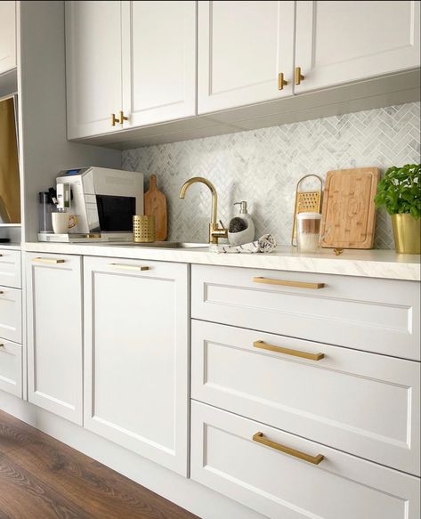 Cream Kitchen Gold Hardware, White Cabinets Gold Knobs, White And Gold Kitchen Aesthetic, Kitchen Ideas With Gold Fixtures, White Kitchen With Gold Fixtures, Kitchen Brushed Gold Hardware, Cream Kitchen Gold Handles, White Shaker Cabinets With Gold Hardware, Sand Colour Kitchen