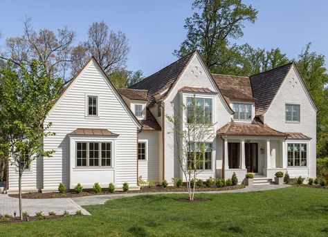 This home seamlessly blends the romanticism of a Tudor home with clean transitional lines, characterized by painted brick, pitched roof lines, and copper metal roofs. Copper Metal Roof, W Design Collective, Tudor Home, Tudor Style Homes, W Design, Tudor House, Tudor Style, Glass Front Door, Painted Brick