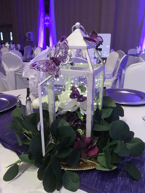 Butterflies in the Lilacs; lovely garden centrepieces for this wedding #lethbridgeeventrentals #lethbridgeevents #wedding #weddingreception #lilac #purple #garden #butterflies #centrepiece #lantern #uplight #backdrop #headtable #weddingdecor Butterfly Wedding Centerpieces, Butterfly Quinceanera Theme, Purple Quinceanera Theme, Butterfly Sweet 16, Quince Centerpieces, Butterfly Wedding Theme, Quince Decor, Butterfly Centerpieces, Sweet 15 Party Ideas Quinceanera