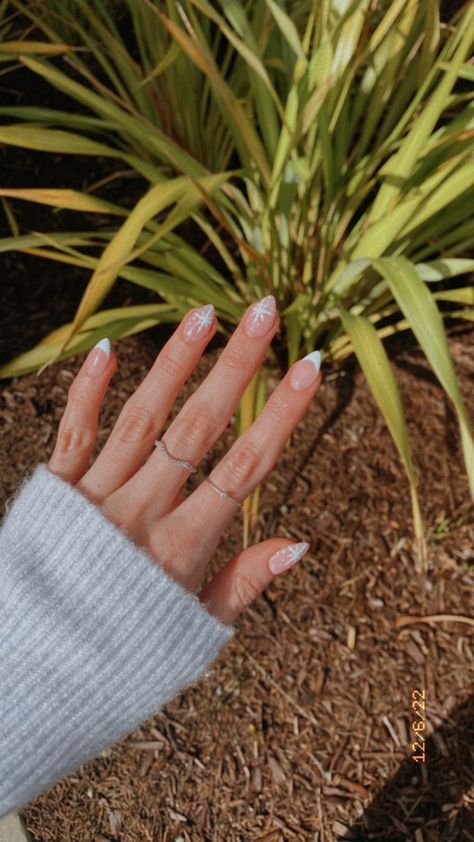 Winter nails with a light blue french tip and snowflake design. Red French Tips With White Snowflakes, White And Blue Snowflake Nails, Snowflake Winter Nails, Light Blue Winter Nails, Light Blue French Tip, Blue French Manicure, Blue French Tip, Blue Christmas Nails, Snowflake Nail Design