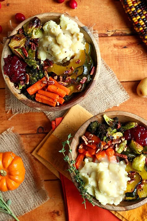 This recipe for a Roasted Vegan Thanksgiving Bowl is perfect for getting you into the holiday spirit, thanks to its blend of savory comfort food ingredients like sweet roasted squash and carrots, roasted garlic broccoli, roasted brussels sprouts, mashed creamer potatoes, and easy gravy sauce. Or, try out this recipe after Thanksgiving for a creative way to use leftovers. Thanksgiving Bowl, Vegan Thanksgiving Dinner, Pudding Chia, Vegan Holiday Recipes, Vegetarian Thanksgiving, Decorações Com Comidas, Vegan Thanksgiving Recipes, Vegan Holidays, Vegan Holiday