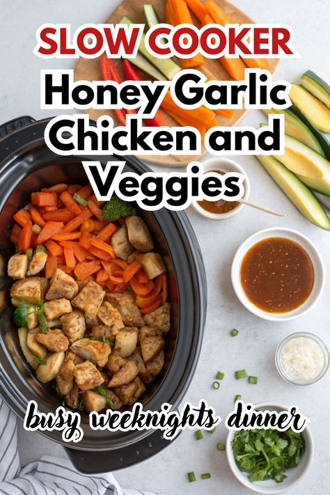 A delicious plate of Crockpot Honey Garlic Chicken and Veggies served alongside broccoli, carrots, and tomatoes. The dish showcases tender, golden-brown chicken pieces drizzled with honey garlic sauce, paired with vibrant, fresh vegetables. In the background, a slow cooker and fresh herbs on a wooden board complete the cozy kitchen scene. Perfect for a simple and flavorful dinner! Clean Crockpot Recipes Healthy, Crockpot Meals With Carrots, Chicken And Broccoli Slow Cooker Recipes, Crockpot Recipes Chicken And Vegetables, Easy Crockpot Meals Whole 30, Easy Healthy Dinner Slow Cooker, Chicken Cubes Crockpot Recipes, Easy Clean Crockpot Meals, Cleanfoodcrush Crockpot Recipes