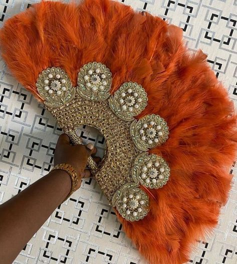 Orange Gold Feather Hand Fan, Clutch Semi-Circle African Traditional Wedding Bridal Hand Fan, Nigerian Wedding Hand fan  NEED OTHER DESIGNS AND COLOURS OF HAND FANS, BRAIDED WIGS, AUTOGELE HEADWRAPS AND AFRICAN CORAL BEADS, VISIT OUR ETSY SHOP HERE: https://sereneafrica.etsy.com This beautifully crafted African bridal accessory adds spice to your outfit on your wedding day. It can also be used by guests at a wedding. Production/ processing time is 1 week. We use DHL Express, it takes 3-5 busines Beautiful Hand Fans, African Hand Fans, African Wedding Headwrap, Nigerian Feather Fan, Bridal Handfan Nigeria, Orange Traditional Dresses African, Nigerian Fans For Wedding, Nigerian Wedding Traditions, Feather Fans Wedding