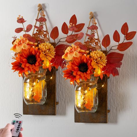 PRICES MAY VARY. 【2 Pack Decorative Jar】One package includes 2 mason jars, 2 rustic wood holders, and LED string lights(batteries not included), and 2 artificial flowers bouquets. The size of wooden board is 10.45*5.19in, the length of LED string is 78.74in. 【Unique Floral Matching】Each bouquet contains six different elements, including a pumpkin,4 chrysanthemums, 2 pine cones, some maple leaves, and other accessories. 【Multiple Lighting Effects】The LED lights feature 6-hour timing and remote co Fashion Decor Bedroom, Mason Jar Sconces, Fall Decorations For Home, Fall Living Room Decor, Wall Decor Rustic, Rustic Wall Sconces, Fall Thanksgiving Decor, Christmas Mason Jars, Decorations For Home