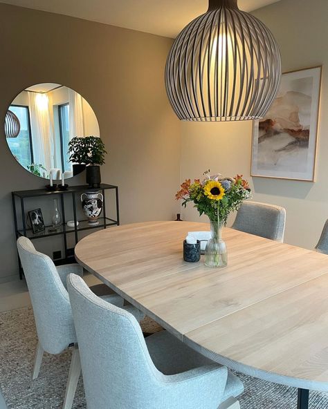 This beige dining room with upholstered dining chairs can create an elegant look, especially by adding a statement chandelier above the dining table. To enhance the neutral color palette, consider adding subtle pops of color through decorative accessories such as vibrant floral arrangements or art pieces. Beige dining room from @casahjartlie Cream Dining Chairs Dark Table, Beige And Grey Dining Room, Cream Dinning Room Table, Taupe & Shell Pink Diningroom, Neautral Area Rugs For Dininng Room, Beige Dining Room, Beige Couch, Carpet Dining Room, Statement Chandeliers