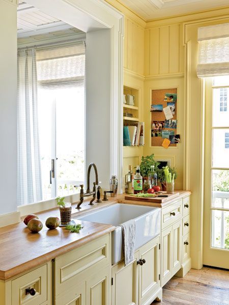 Airy coastal cottage kitchen with yellow painted walls and cabinets Kitchen Butcher Block Countertops, Coastal Cottage Kitchen, Sink Window, Kitchen Butcher Block, Yellow Cabinets, Cottage Kitchens, Coastal Kitchen, Yellow Kitchen, Butcher Block Countertops