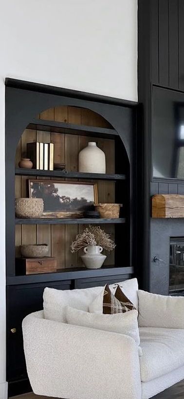 Fireplace Built Ins Black, Black Cabinets Next To Fireplace, Black And Wood Built In, Arched Living Room Built Ins, Built In Arch Bookshelves, Two Tone Built Ins Bookshelves, Rounded Built Ins, Paint Built In Bookcase, Modern Tudor House Interior