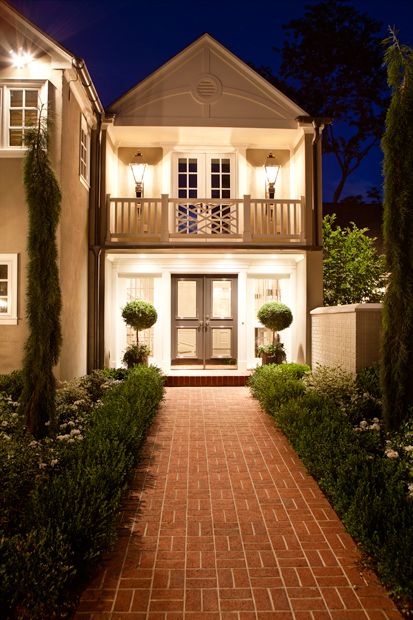 Elizabeth Kimberly Design - home exteriors - carriage house, iron lanterns, boxwood hedges, red brick pathway, bay topiaries, ivy, black front door, juliet balcony, chippendale balustrade, brick pathway, Balcony Over Porch, French Home Exterior, Transitional Home Exterior, Modern French Home, Brick Pathway, Juliet Balcony, House With Balcony, Red Brick House, Casa Exterior