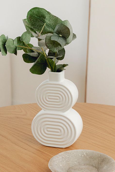 This white architectural vase offers a whimsical design featuring a curved silhouette and a glossy glaze. Coordinate with the Zoel Ceramic Vase for maximized impact. Sculptural shape Etched design Glossy finish Ceramic Abstract Vases Ceramic Pottery, Coil Vase Ceramics, Vase Ideas, Slab Vase, Paint Brush Holders, Slab Ceramics, Etched Designs, Clay Vase, Furniture Trends