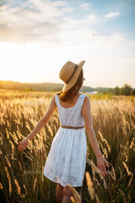 Woman in dress walking in wheat field on sunset by NomadSoul1. Woman in white dress and straw hat walking in wheat field on sunset. Female person on summer meadow, back view #Affiliate #field, #sunset, #wheat, #Woman Straw Field Photoshoot, Woman In Wheat Field, Women In Dresses Photography, Portraits In A Field, Wheatfield Photoshoot, Wheat Photoshoot, Person Back View, Back View Poses, Corn Field Photoshoot