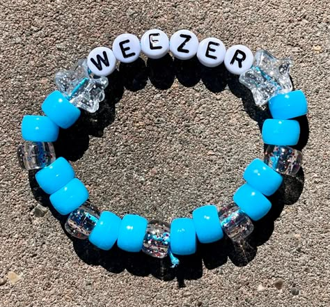 Weezer inspired kandi bracelet perfect to wear for a weezer concert ;) Variations are options now, too many people were putting down very wrong sizes in personalization, if you have a question about the size contact me ASAP, I tend to ship out very quickly! please remember bracelets like these are elastic so they will be able to accommodate for a bigger wrist :)  sizes are in inches measured around the wrist , not along the top of the wrist Elastic Band Bracelets, Band Kandi Bracelets, Weezer Bracelet, Weezer Kandi, Scene Kandi Bracelets Ideas, Funny Kandi Bracelets, Weezer Concert, Funny Bracelets, Kandi Bracelet Ideas