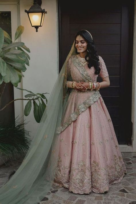 When it comes to wedding lehengas, red has always been a favourite with brides. But off late, brides are giving the traditional red lehenga a miss and opting for a different and unique hue when it comes to picking up their bridal lehenga – powder pink! A pale shade of pink that is in the pastel family has been a bridal favourite off late for your wedding day. It’s perfect for a day wedding as well as an evening soiree, light enough to not overpower you as well as unique enough to style. Pastel Pink Bridal Lehenga, Pastel Pink Lehenga, Green Indian Wedding, Pink Indian Wedding, Bridal Lehenga Images, Sabyasachi Lehenga Bridal, Pink Bridal Lehenga, Pastel Pink Weddings, Pink And Green Dress