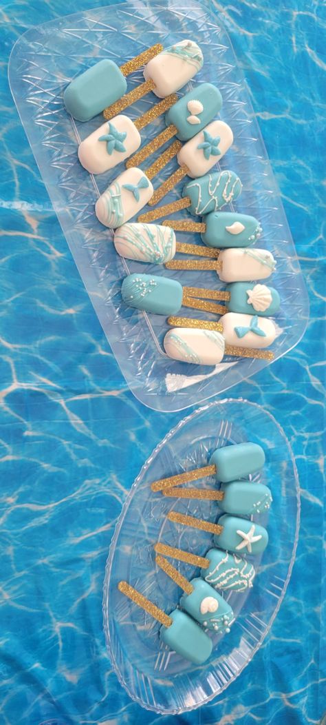 Blue and white ocean themed cakesicles with chocolate shells and mermaid tails. Beach Theme Cakesicles, Blue Cake Pops, Chocolate Party Favors, Ocean Stuff, Ocean Cakes, Baby Whale, 1st Birthday Themes, Chocolate Shells, Summer Cakes