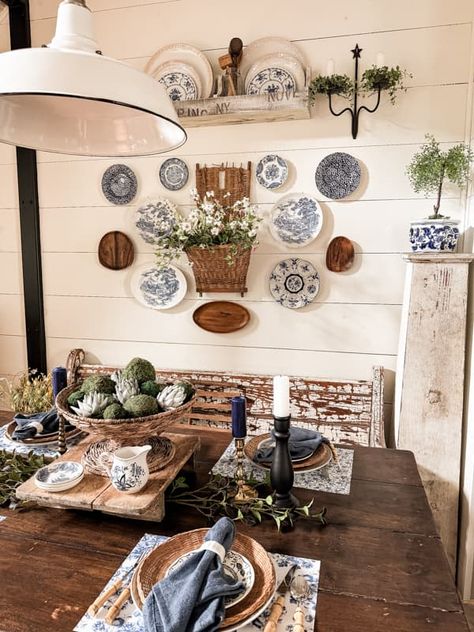 Decorate dining room wall with plate wall decor and vintage basket beside the farmhouse table. Plates And Pictures On Wall, Plates Around Picture On Wall, Decorative Plates On Wall Kitchen, Wall Collage With Baskets, Decor Plates On Wall, Plates In Frames Wall Decor, Decorating With Plates On Wall Ideas, Using Plates As Wall Decor, Dining Room Vintage Decor