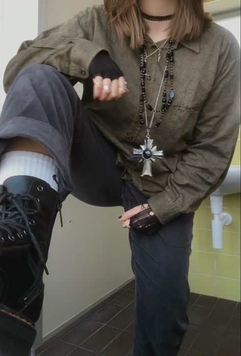 A mid-size person/girl wearing a closed dark green thrifted flannel, a black ripped tights top underneath funtioning as arm warmers, black corduroy jeans, black platform dr. Martens and multiple crystal rings and bracelets. 	The person is also wearing multiple silver necklaces, one in form of a fairy and another in form of a moon and a black lace choker. Green Flannel Outfit Aesthetic, Layered Shirts Outfit, Goblincore Aesthetic Clothes, Green Grunge Outfit, Fit Aesthetic Outfit, Brown Flannel Outfit, Green Flannel Outfit, Flannel Outfits Aesthetic, Ftm Outfits