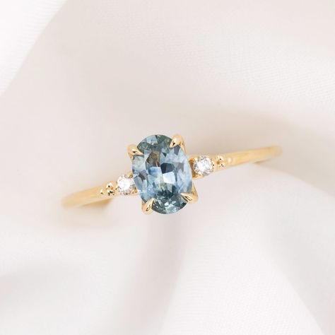 * One of a kind ring * In stock ready to ship in size 7.25 * 0.93ct Oval Cut Montana Sapphire Light Blue 7.02x5.05x3.07mm, vvs clarity, Heated * Bandwidth: approx. 1.4mm * Natural accent diamonds 0.04ctw * Elevated four prongs flower setting * Ethically sourced solid 14k yellow gold and gemstones * Packaged in a recyclable kraft ring box Light Blue Diamond Engagement Ring, Pale Blue Engagement Ring, Light Blue Sapphire Ring, Light Sapphire Engagement Ring, Saphire Engament Ring Gold Band, Light Blue Engagement Ring, Coloured Engagement Rings, Light Blue Sapphire Engagement Ring, Oval Engagement Ring Gold