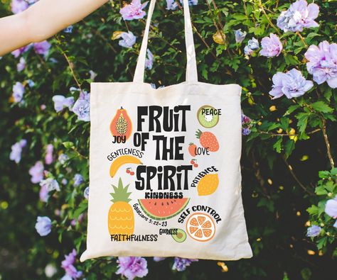 Carry your faith with our stylish Fruit of the Spirit Tote Bag. Made of durable canvas, this spacious bag features a meaningful Bible verse. Perfect for Christian girls, churchgoers, and as a religious gift. Embrace your Christian values wherever you go. Order now! This 100% cotton bag comes in one size - 15" x 16"- perfect for everyday wear. While the canvas material will show off your designs in great colors, it's durable and will last for years. The bag features 20" handles (made from the sam Tote Bag Painting Ideas Bible Verse, Sublimation Canvas Bag Ideas, Christian Tote Bags Paint, Jesus Tote Bag Painting Ideas, Bible Bag Ideas, Bible Tote Bag Diy, Christian Tote Bag Design Diy Paint, Diy Bible Bag, Bible Bags Totes Diy Paint