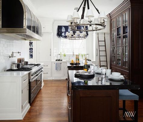 A cook's kitchen features pair of black leather strap chandeliers, Ralph Lauren Westbury Chandeliers, illuminating side by side walnut islands topped with black marble facing a walnut china cabinet with glass doors. Kitchen Deisgn, Walnut Kitchen Cabinets, Cooks Kitchen, Calcutta Gold, Main Kitchen, Patina Farm, Front Kitchen, Grey Kitchen Island, South Shore Decorating