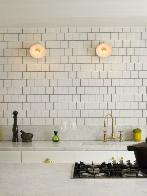 Like: White tile. Dark grout. Brass bridge faucet with gooseneck spout. Brass cabinet hardware. Industrial utility lights. Top Kitchen Trends, White Kitchen Backsplash, White Ceramic Tiles, Herringbone Backsplash, Kitchen Backsplash Designs, Kitchen Splashback, Kitchen Marble, Square Tile, Kitchen Trends