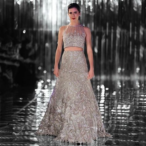 With a signature sheer neckline laced with shimmer, the blouse is paired with a lehenga skirt adorned with floral threadwork cascading down to 3D florals at the hem. #SensualAffair #ManishMalhotraLabel @manishmalhotra05 Designer Bridal Lehenga Manish Malhotra, Lehenga Manish Malhotra, Manish Malhotra Lehenga, Lehenga Top, Reception Gowns, Bridesmaid Lehenga, Walima Dress, Bridal Lehenga Designs, Wedding Lehengas