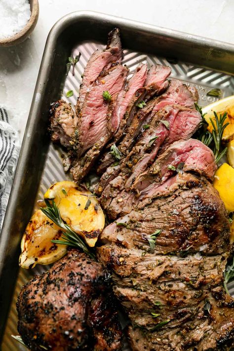 This Butterflied Grilled Leg of Lamb is the ultimate summer feast! Slather boneless / butterflied leg of lamb in a Mediterranean-inspired marinade made of lemon, garlic, & herbs. Cook on the grill until perfectly charred yet super juicy & meltingly tender. Serve with pita & a mezze platter or a few simple sides – grilling butterflied leg of lamb is SO simple & makes the best backyard Sunday supper with family & friends! #grilledlamb #grilledlambleg #grilledlambrecipes #legoflamb #... Grilled Lamb Recipes, Grilled Leg Of Lamb, Summer Feast, Butterflied Leg Of Lamb, Lamb Roast Recipe, Lamb Marinade, Mezze Platter, Simple Sides, Boneless Leg Of Lamb