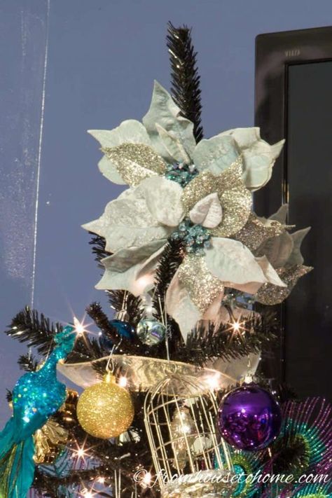 I love this step by step guide for how to decorate a Christmas tree. It has some great tips for making your Christmas tree decorations look awesome! And I love the glam purple, gold and blue color scheme. | Holidays and Events Christmas Pictures With Lights, Decorate Tree, Peacock Christmas Tree, Poinsettia Tree, Decorate A Christmas Tree, Blue Christmas Ornaments, Peacock Christmas, Tree Beautiful, Blue Christmas Decor