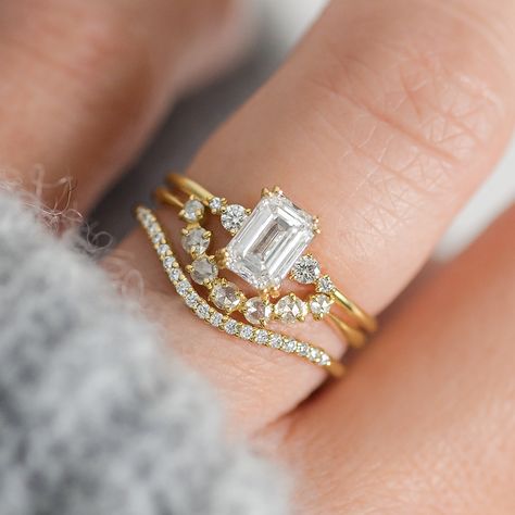 Two words we love: are shine and stunning. That's how we'd describe the beautiful emerald cut diamond engagement ring. Emerald Engagement Ring With Band Gold, Emerald Cut Engagement And Wedding Ring Sets, Cluster Engagement Rings, Stone Drawing, Diamond Centerpiece, Handcrafted Engagement Ring, Emerald Cut Diamond Engagement Ring, Timeless Engagement Ring, Melanie Casey