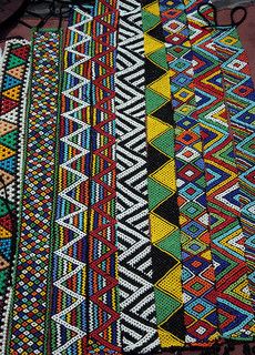 Clive Reid - Colourful African beadwork displayed for sale on the Durban beachfront. Zulu Beads, African Pattern Design, South African Art, Afrique Art, Afrikaanse Kunst, Colors And Patterns, African Textiles, Africa Art, African Pattern