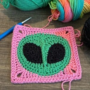 Weird Granny Squares, Alien Granny Square Free Pattern, Funny Granny Squares, Eyeball Granny Square Pattern Free, Alien Head Granny Square, Alien Granny Square Pattern, Unique Crochet Projects Ideas, Alien Granny Square, Crochet Eyes Granny Square