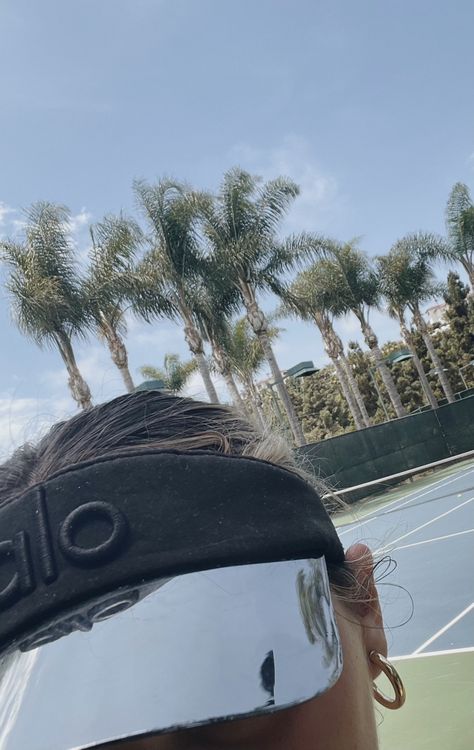 wearing a black alo visor on the tennis court Tennis