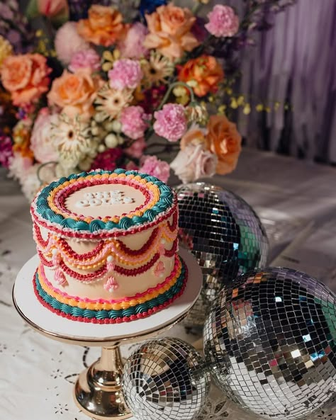 This colourway 👌🏼 @wolfandwildflowerphotography @wolfandthewildflowers_ @rundletailoring @hellofleur_ @confettipartyhire @eventstoadore @emmah.jane.made #vintagevibes #vintagestyle #bespokecake #spodeli #vintagecakesnewcastle #spodelinewcastle #vintagecake #retro #retrocake #vintageweddingcake #lambethcake #heartcake #heartshapedcake #vintageheartcake #roccoco #newcastle #vintageweddingcake #whiteonwhite #renaissance #cakepiping #cakedecorating Boho Disco Wedding Cake, Eclectic Wedding Cake, Colorful Vintage Cake, Primary Color Cake, Maximalist Cake, Retro Cake Design, 70s Cake, Retro Wedding Cake, Beatles Cake