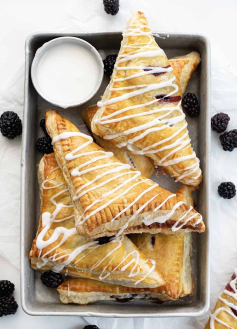 Blackberry Cream Cheese Turnovers are puff pastry squares filled with cream cheese and a homemade blackberry sauce, baked and drizzled with a sweet glaze. They are delicious as a breakfast pastry or a sweet treat for dessert. And, they can also be made in an air fryer! Blackberry Puff Pastry, Cream Cheese Turnovers, Homemade Toaster Strudel, Blackberry Cream Cheese, Puff Pastry Squares, Cheese Turnovers, Pastry Squares, Easy Puff Pastry Recipe, Cream Cheese Puff Pastry