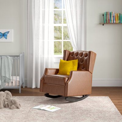 This rocking chair is sure to be the go-to seat in your home for relaxing, napping, or soothing a cranky baby. We love the classic wingback style that makes this handsome rocker a great addition to your traditional or transitional design aesthetic. It has an engineered wood frame that’s wrapped with foam and easy-care faux leather that wipes clean with a damp cloth. What’s more, the backrest has deep button tufting for a boast of visual texture. The twin rockers are stained with a warm birch hue Brown Rocking Chair, Baby Glider, Upholstered Rocking Chair, Upholstered Rocking Chairs, Rocking Armchair, Nursery Glider, Nursery Chair, Visual Texture, Design Aesthetic