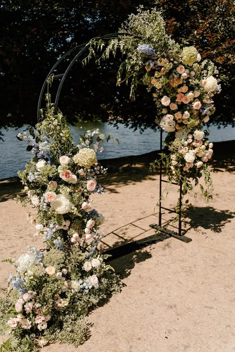 Black steel arch complete with floral decor by the River Thames Garden Arch Wedding, Modern Arch Wedding, Doughnut Tower, Winter Wedding Arch, Dried Petal Confetti, Flower Archway, Table Dance, Flower Arches, Soft Sunset