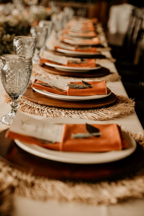 Layered table setting, topped with a burnt orange velvet napkin! This table setting makes for the perfect boho chic vibe! #BohoWedding #Bohochicwedding #RusticWedding #BurntOrange #WoodenCharger #BruntOrangeVelvetNapkin #FallWedding Burnt Orange Decorations, Fall Burnt Orange Wedding, Terracota Table Setting Wedding, Boho Terracotta Wedding Tables, Boho Napkins Table Settings, Velvet Table Setting, Burnt Orange Wedding Table Decor, Burnt Orange Wedding Table, Boho Terracotta Wedding Table Setting