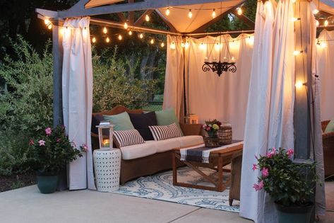 Pergola with edison bulb lights, canvas curtains and cozy seating at dusk Canvas Curtains, Diy Bamboo, Pergola Curtains, Farmhouse Patio, Cheap Pergola, Pergola Lighting, Pergola Attached To House, Pergola Design, Wooden Pergola