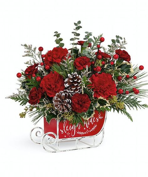 Dashing through the snow in a flower-filled open sleigh! Fun and festive, this vintage metal keepsake sleigh is the perfect vehicle for a joyful holiday bouquet. Red carnations, miniature red carnations and white filler are accented with assorted greens and evergreens and artistically arranged in Vintage Sleigh Ride Keepsake. Approximately 13 1/2" W x 12 1/2" H #FlowerKingdom Floral Christmas Arrangements, Sleigh Decorations, Christmas Sleighs, Christmas Floral Arrangements Diy, Christmas Sleigh Decorations, Vintage Sleigh, Holiday Bouquet, Holiday Flowers, Christmas Bouquet