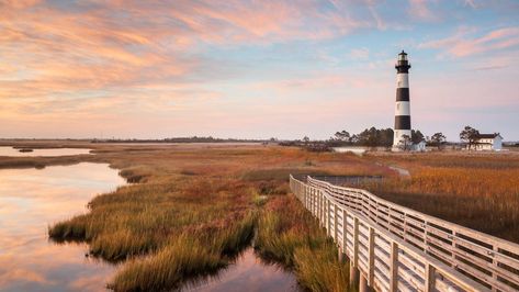 This classic tourist destination became America's first national seashore in 1953 and covers more than 70 miles of coastline and 30,000 acres of beaches, dunes, marshes and woodlands in North Carolina’s Outer Banks. The seashore preserves three iconic lighthouses, constructed to aid sailors navigating the cape’s perilous coastline. Visitors will also find a rich diversity of plant and animal life, including more than 360 documented bird species, and a range of historical sites commemorating ... Bodie Island Lighthouse, Cape Hatteras National Seashore, Ocracoke Island, Cape Hatteras, Carolina Beach, Summer Getaway, Bank Of America, Scenic Drive, Great Smoky Mountains