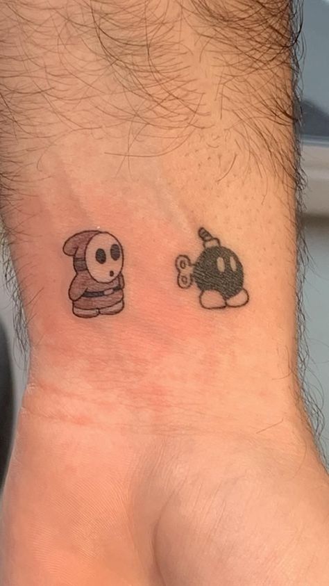 Shy Guy Mario Tattoo, Shy Guy Tattoo Design, Mario Matching Tattoos, Bob Omb Tattoo, Small Mario Tattoo, Shy Guy Tattoo, Cars Tattoo Disney, Rapper Tattoos Ideas, Doodle Bob Tattoo