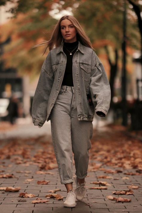 A woman strolling down a leaf-covered street in autumn, styled in an oversized denim jacket, high-waisted mom jeans, and white sneakers for a casual fall fashion vibe. Oversized Denim Jacket Outfit, Classic White Sneakers, Denim Jacket Outfit, Autumn Days, High Waisted Mom Jeans, Oversized Denim Jacket, City Streets, Fall Looks, Autumn Day