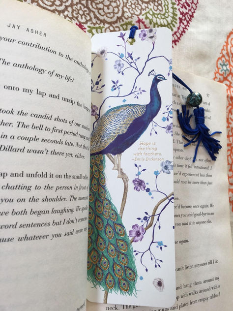 Bookmark of an elegant peacock with blue and purple flowers on a white background. Featuring a blue tassel and green bead. Peacock Bookmark, Peter Pauper Press, Diy Bookmark, Hope Is The Thing With Feathers, Beaded Bookmarks, Majestic Creatures, Art & Craft Paint, Famous Poems, Teeth Jewelry