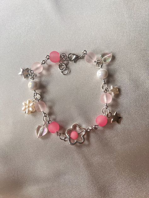 This bracelet is made with glass and acrylic beads with metal charms on silver wire.  Bracelet is 8 in in length including chain extender. Cheengu Pink, Pink Bracelets, Bracelet Y2k, Cross Bracelets, Charm Accessories, Astoria Ny, Chunky Bracelet, Bracelets Design, Diy Charm Bracelet