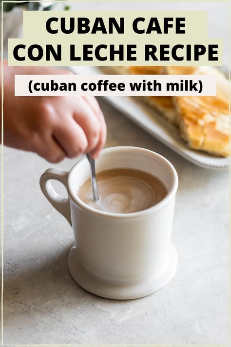 A white mug with cuban cafe con leche with a hand stirring with a spoon and cuban toast in the background and the words "cuban cafe con leche recipe (cuban coffee with milk)" in the foreground Cuban Dessert Recipes, Cuban Toast, Cafe Con Leche Recipe, Cuban Coffee Recipe, Cuban Espresso, Cubano Coffee, Café Cubano, Drinks Liquor, Jamaican Coffee