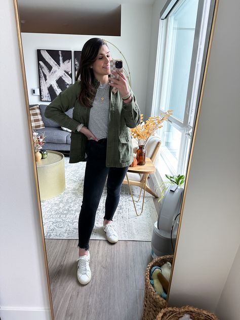 Woman mirror selfie wearing a green utility jacket, striped white & black shirt, black skinny jeans, and white Veja sneakers for a rainy fall outfit Green Outerwear For Rainy Weather, Green Anorak Jacket Outfit, Green Rainy Season Outerwear, Trendy Green Button-up Utility Jacket, Casual Green Button-up Utility Jacket, Rainy Fall Outfit, Green Utility Jacket, Early Fall Outfits, Rainy Day Outfit