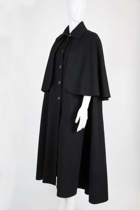 For Sale on 1stdibs - Iconic 1970s Yves Saint Laurent black wool cape coat featuring a front silver tone button opening, inside slits to pass arms.. In excellent vintage condition. Vintage Cape Coat, Trench Coat Spring, Black Cape Coat, January Fashion, Twenties Style, 2009 Runway, Wool Cape Coat, Open Coat, Cape Fashion