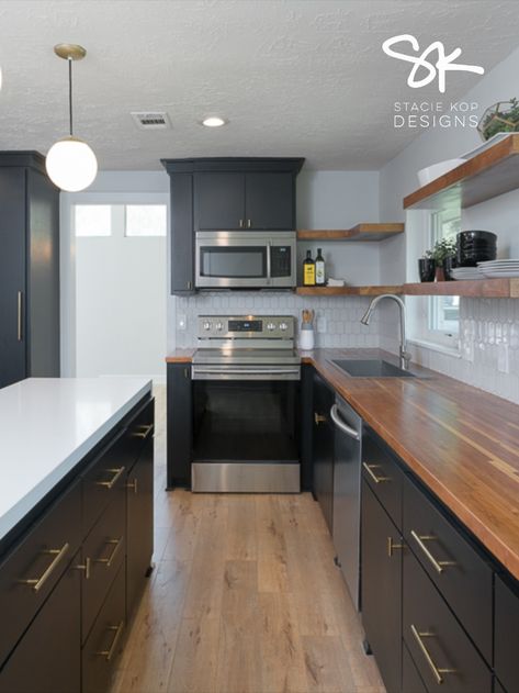 Black Cabinets, butcher block counters, quartz waterfall counter on island, open shelving || Designed by Stacie Kop Designs #kitchendesign #kitchenideas #kitchen #midmodkitchen Butcher Block And Granite Countertops Together, Black Kitchen Cabinets With Concrete Countertops, Kitchen With Butcher Block And Quartz, Butcher Block Countertops Quartz Island, Butcher Block Countertops With Quartz Island, Butcher Block And Quartz Countertops Kitchen, Black Cabinet With Butcher Block, Dark Cabinets And Butcher Block, Modern Farmhouse Black Kitchen Cabinets