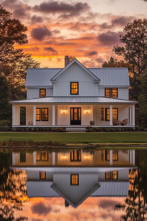 Modern farmhouse with sunset reflection on a pond. Modern country farmhouses mix rustic charm with sleek style, making city folks rethink skyscrapers for tractor beams. White Metal Roof House, Barn House Aesthetic, House Modern Farmhouse, Metal Roof Houses, Sunset Reflection, Brick Steps, White Siding, Grand Entryway, Cottage Modern