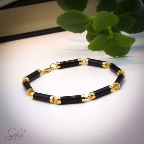 Genuine black onyx tube-shaped bracelet set in solid 14k yellow gold. A sleek and modern piece that will add a touch of sophistication to any outfit. -Black Onyx Properties: Support, Stamina, and Determination -Gift packaging included in all orders -Made in Canada -Woman-Owned Canadian Business Black And Gold Bracelet, Casual Black Onyx Bracelets, Elephant Hair Bracelet Gold For Men, Modern Onyx Bracelet, Modern Black Onyx Bracelets, Hand-strung Onyx Bracelets As A Gift, Mens Bracelet Gold Jewelry, Black Onyx Bracelets For Men, Mens Bracelet Fashion